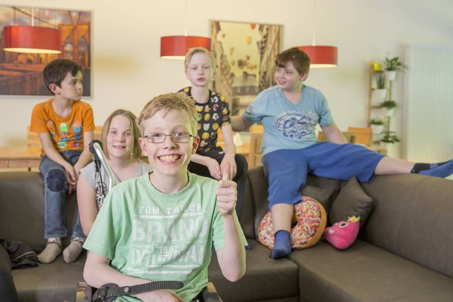 Interntasschüler:innen sitzen auf der Couch und befinden sich gut gelaunt im Wohnzimmer der Internatsgruppe.