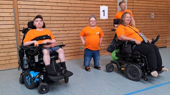 Zwei Schüler:innen und zwei Erzieher befinden sich in der Sporthalle beim Kinder- & Jugendsportfest des Badischen Behinderten- und Rehabilitationssportverbands (BBS) in Baden-Baden.