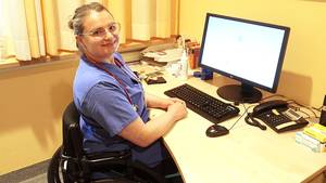 Xenia, ehemalige Schülerin der SRH Stpehen-Hawking-Schule, an ihrem Arbeitsplatz; am Schreibtisch vor dem PC