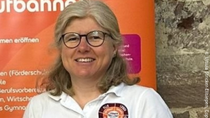 Frau Ursula Stricker-Ellsiepen, Referentin Märkte und Kunden der SRH Schulen GmbH, steht vor einem Roll-up und schaut in die freundlich in die Kamera.