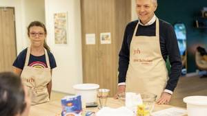Der Geschäftsführer der SRH Bildung GmbH und zwei Internatsschülerinnen backen gemeinsam Waffeln.