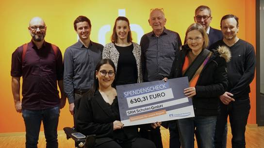 Gruppenbild der Spendenübergabe inklusive Spendenscheck-Übergabe