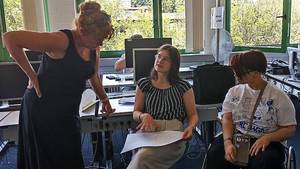 Die Künstlerin Gulfira Stemper steht links im Bild und bespricht mit zwei Schüler:innen der SRH SHS die Kunsttheorie.