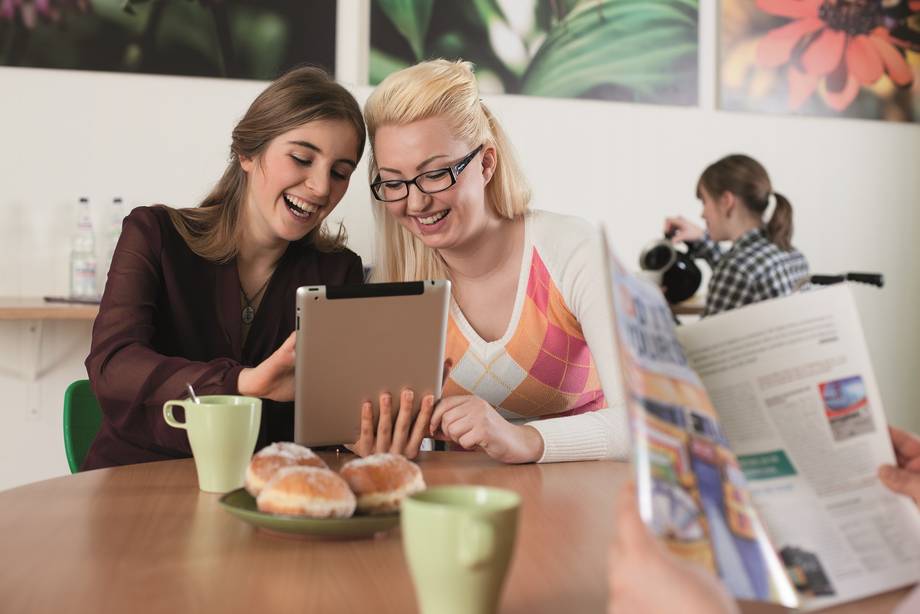 Zwei Schülerinnen schauen sich etwas im Tablet an.