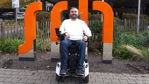 Zurück an der SRH SHS: Ibrahim zu Besuch an seiner früheren Schule vor den Leuchtbuchstaben am Haupteingang.