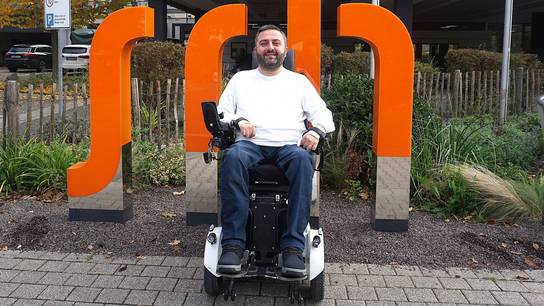 Zurück an der SRH SHS: Ibrahim zu Besuch an seiner früheren Schule vor den Leuchtbuchstaben am Haupteingang.